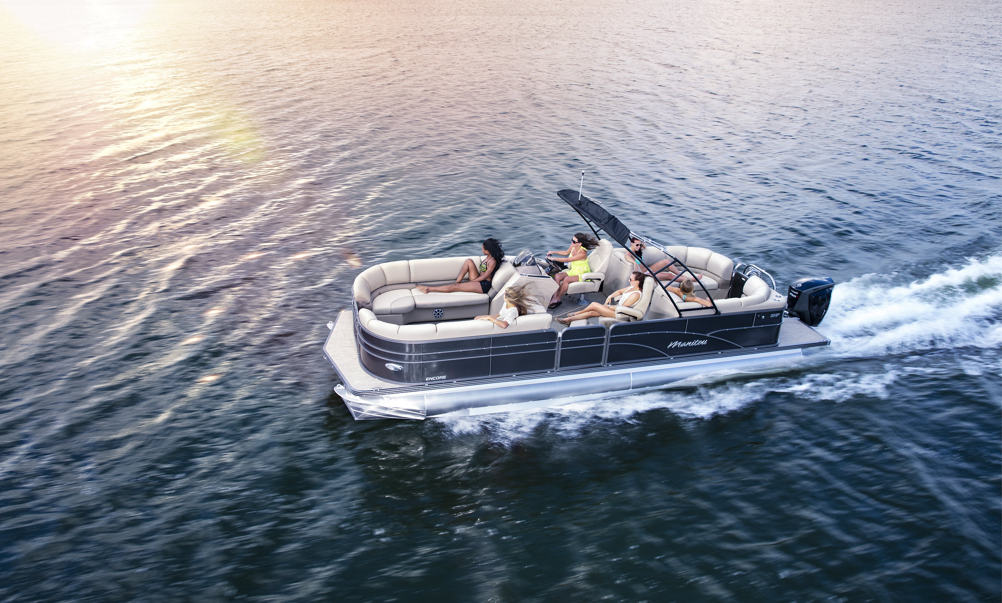 A group of people onboard an underway pontoon.