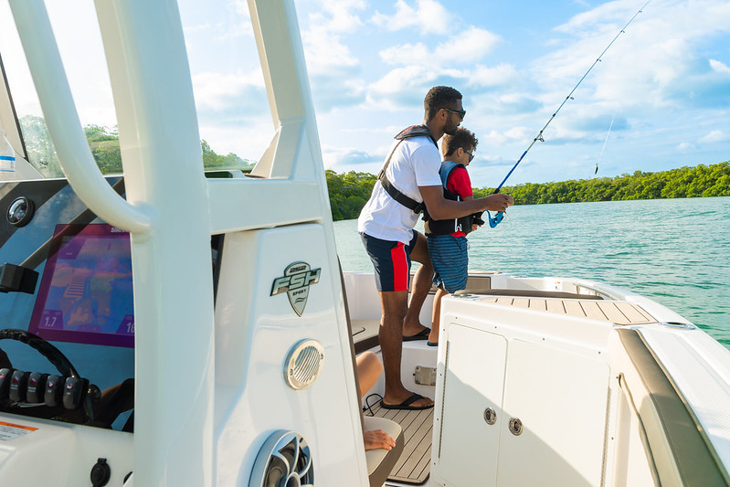 a man and his son fishing on a boat, probably looking for bass