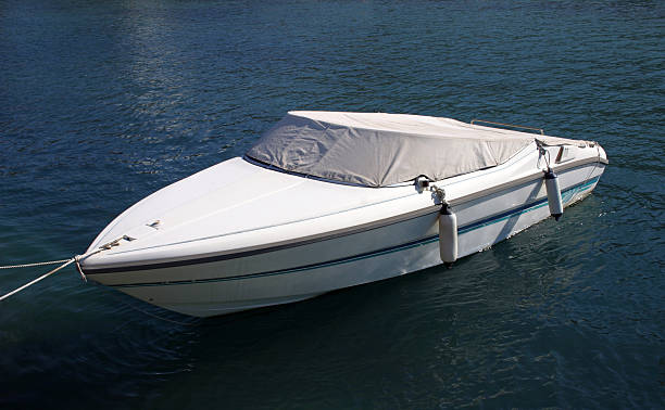 A moored boat with a cover and fenders.
