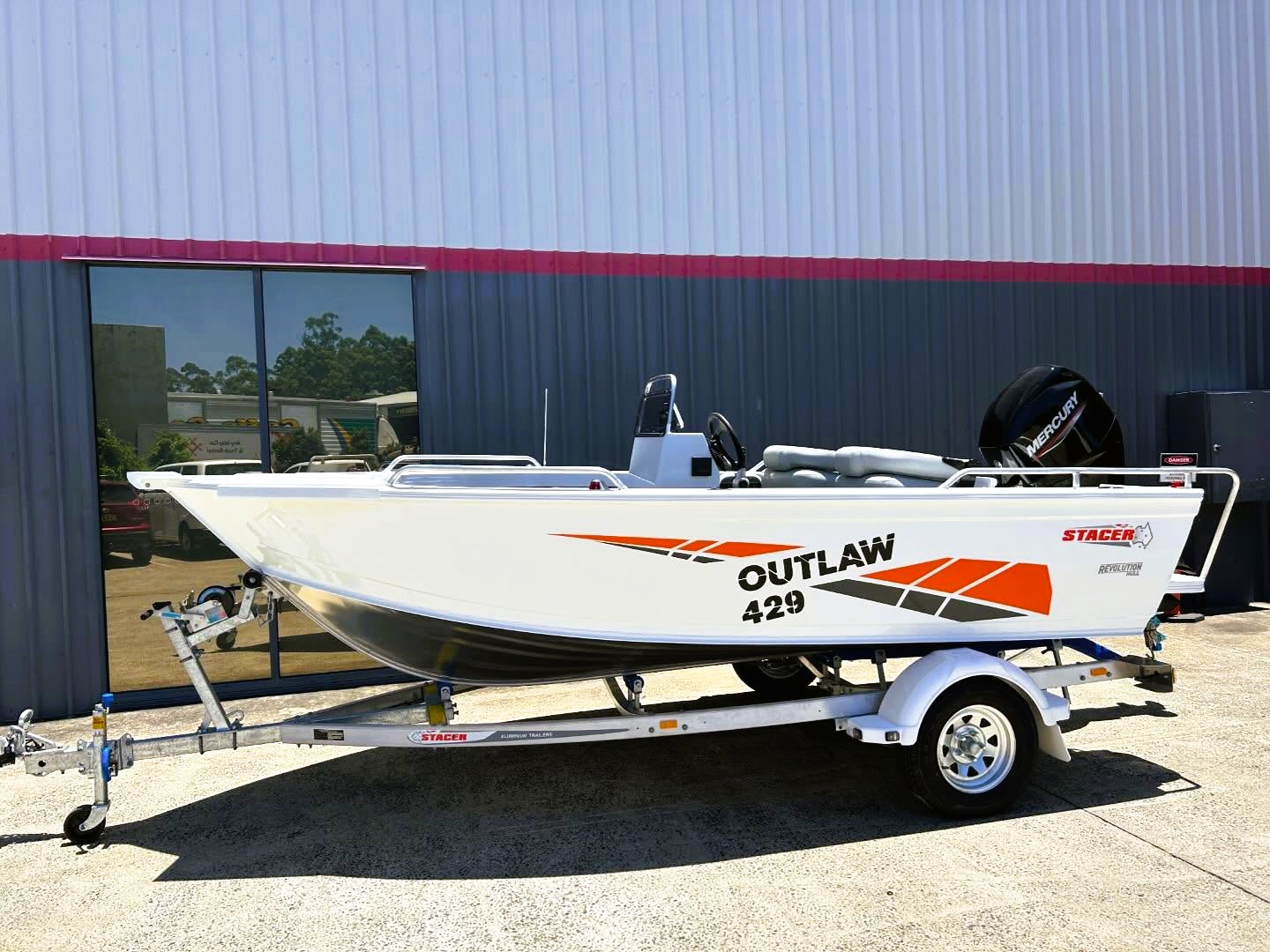 stacer outlaw with a mercury outboard placed on top of a trailer