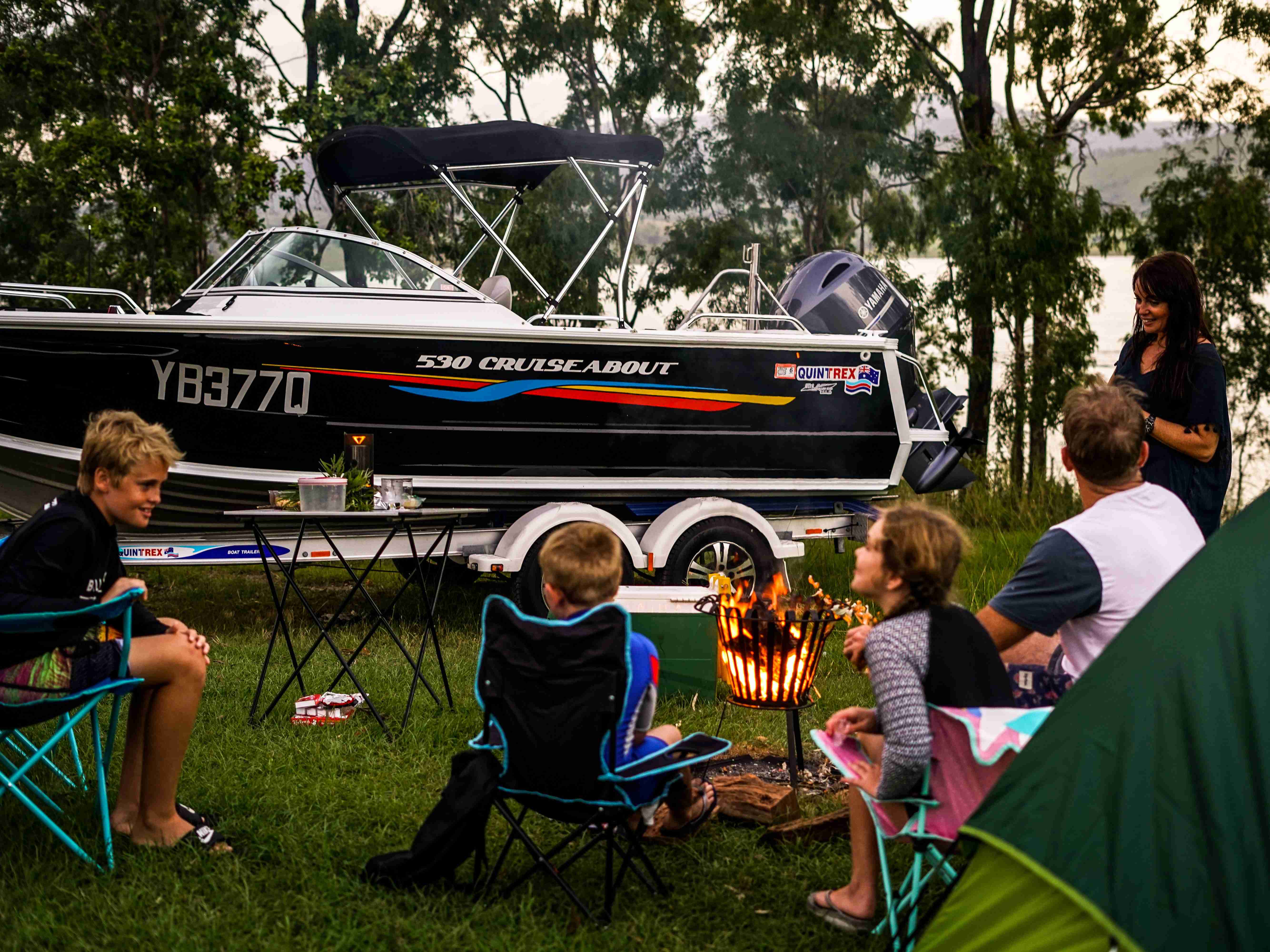 cruiseabout boat on a trailer with a family picnicking infront of the boat