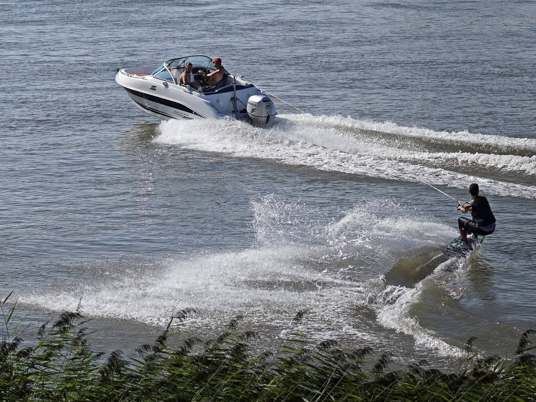 A group of small open boats with outboards attached anchored in shallow waters.