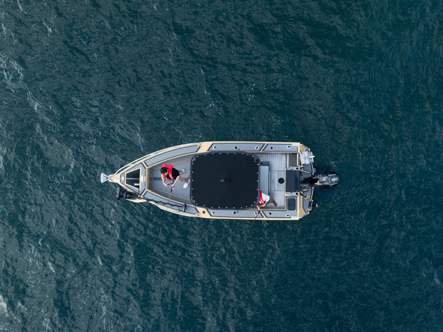 Two people fishing onboard a Yellowfin boat